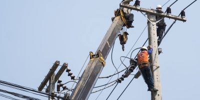 Selective focus of electricians are fixing power transmission line on a electricity pole