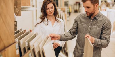 Young couple choosing tiles at building market